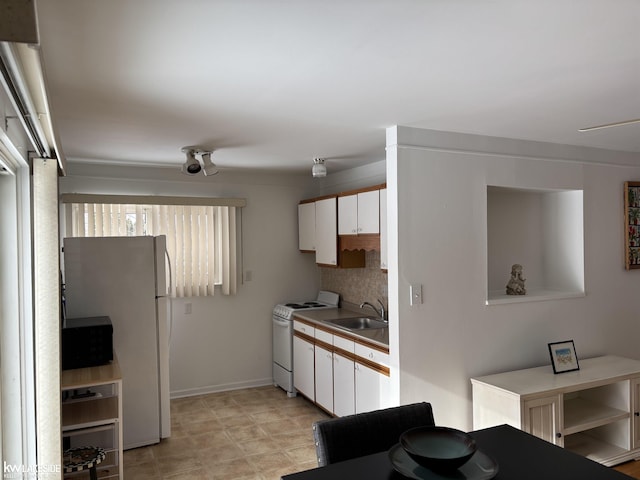 kitchen with sink, white appliances, decorative backsplash, and white cabinets