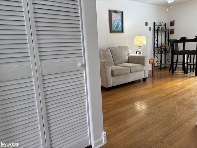 living room featuring ceiling fan, hardwood / wood-style flooring, and crown molding