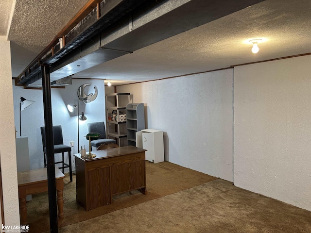 basement featuring a textured ceiling, ornamental molding, and dark colored carpet