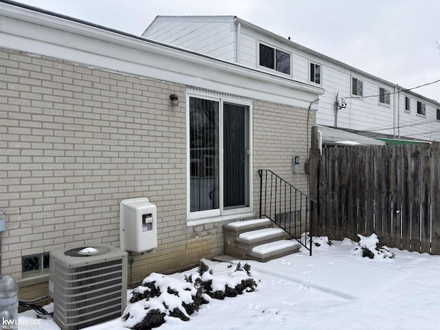 snow covered patio featuring cooling unit