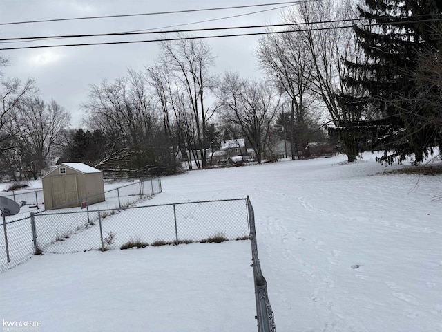 yard layered in snow featuring a storage shed