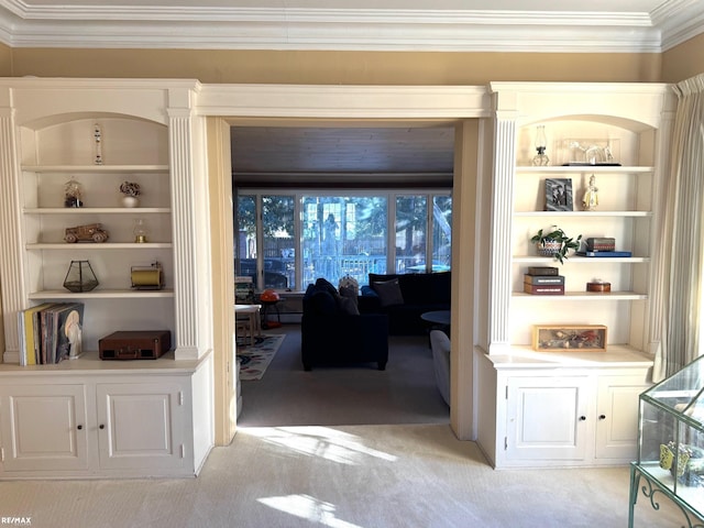 hallway with built in shelves, light colored carpet, and ornamental molding