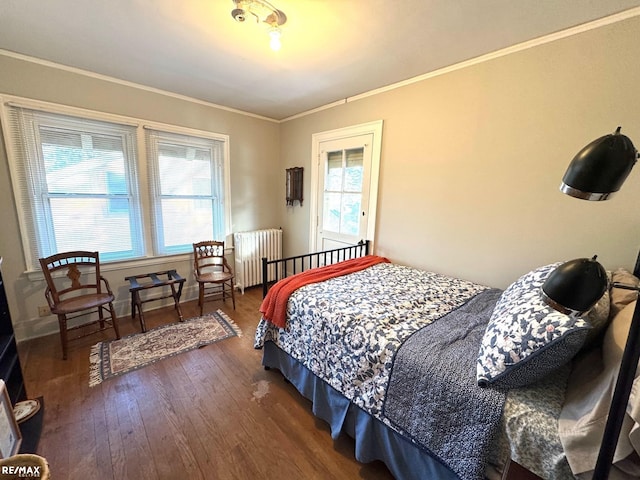 bedroom with dark hardwood / wood-style flooring, radiator heating unit, and crown molding