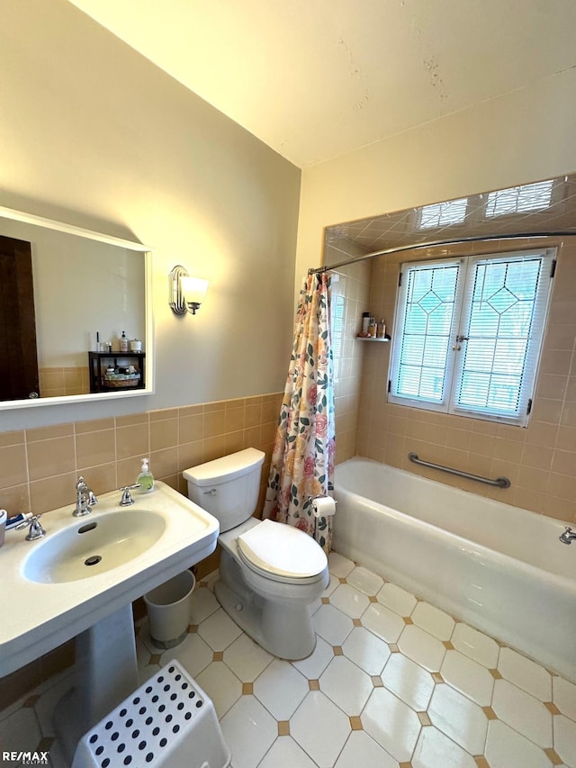 full bathroom featuring tile walls, toilet, shower / tub combo, and sink