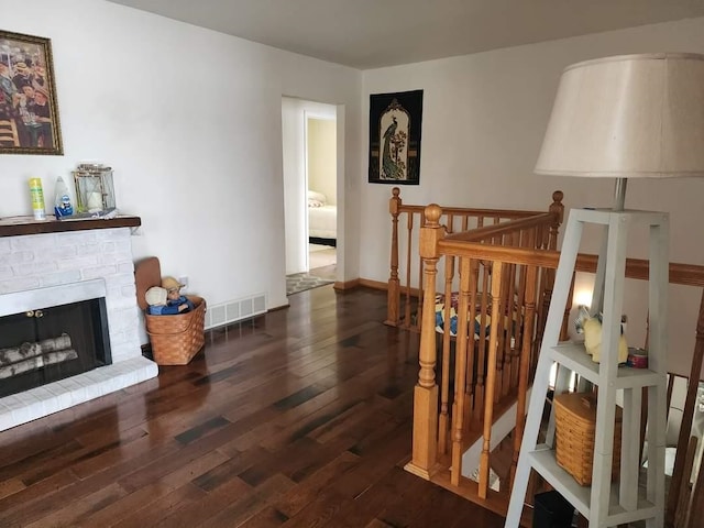 interior space with wood-type flooring and a brick fireplace