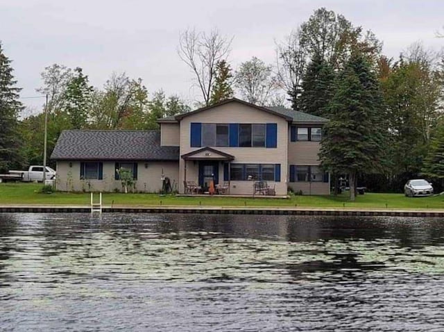 view of front of property featuring a front yard and a water view