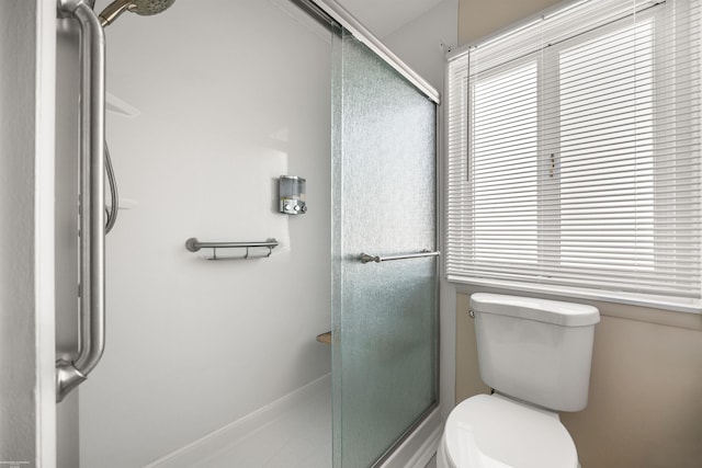 bathroom with toilet and a shower with door