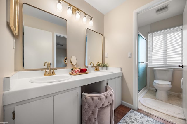 bathroom with toilet, an enclosed shower, vanity, and hardwood / wood-style floors