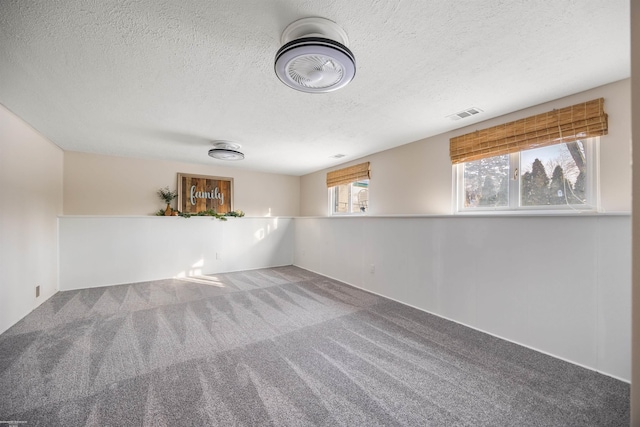 carpeted empty room with a textured ceiling