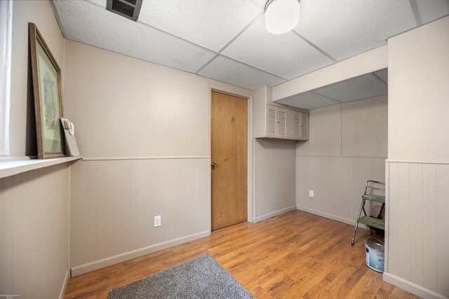 interior space featuring light wood-type flooring and a drop ceiling