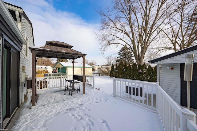 yard covered in snow featuring a gazebo and a wooden deck