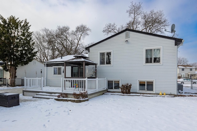 snow covered back of property featuring a gazebo and a wooden deck