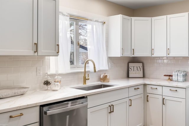 kitchen with dishwasher, light stone counters, sink, white cabinetry, and tasteful backsplash