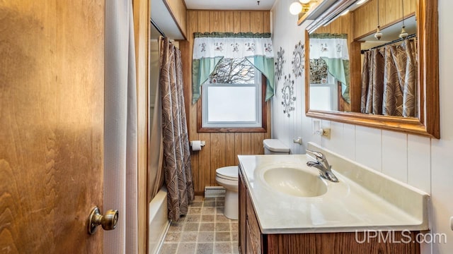 full bathroom featuring toilet, shower / bath combo with shower curtain, wood walls, and vanity