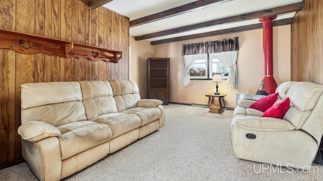 living room with wood walls, beam ceiling, and light colored carpet