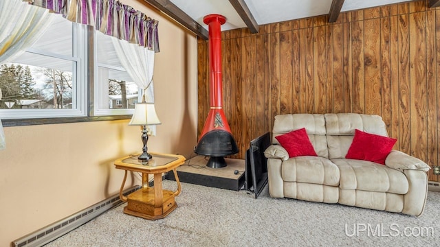 living area with carpet, wood walls, beamed ceiling, and a baseboard heating unit