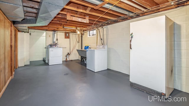 basement featuring separate washer and dryer and sink