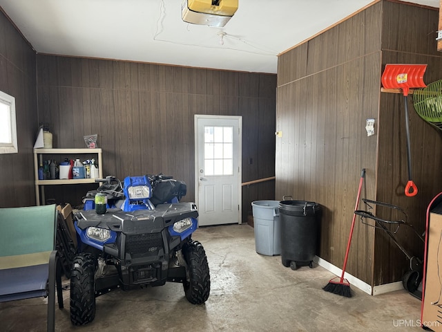 garage featuring a garage door opener and wooden walls