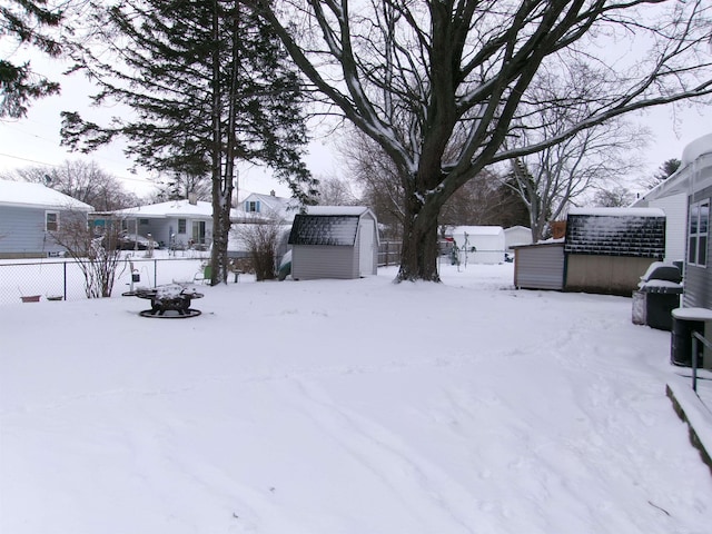 yard covered in snow featuring a storage unit