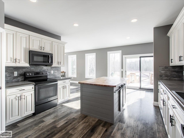 kitchen featuring stainless steel range with electric stovetop, white cabinetry, butcher block countertops, decorative backsplash, and dark hardwood / wood-style flooring