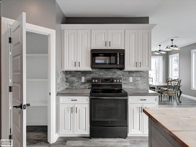 kitchen featuring black range with electric stovetop, decorative backsplash, white cabinetry, and hardwood / wood-style flooring