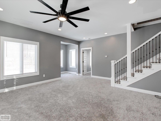 unfurnished living room featuring ceiling fan and carpet