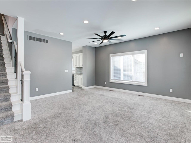 unfurnished living room featuring ceiling fan and light carpet