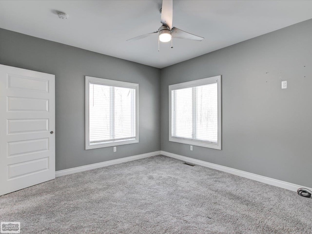 empty room featuring ceiling fan and light colored carpet