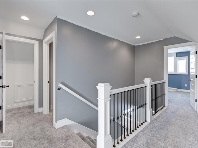 hallway with lofted ceiling and light carpet