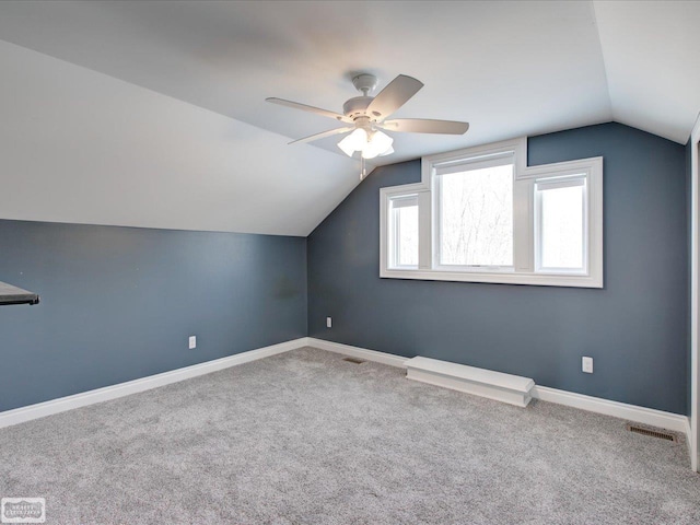 additional living space featuring vaulted ceiling, ceiling fan, and carpet flooring