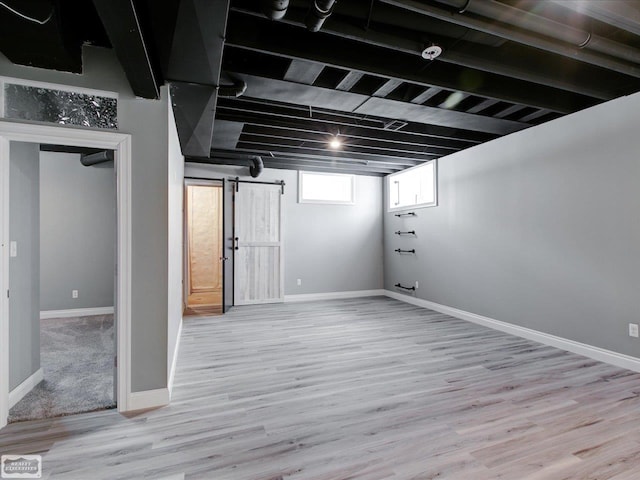 basement with light hardwood / wood-style flooring