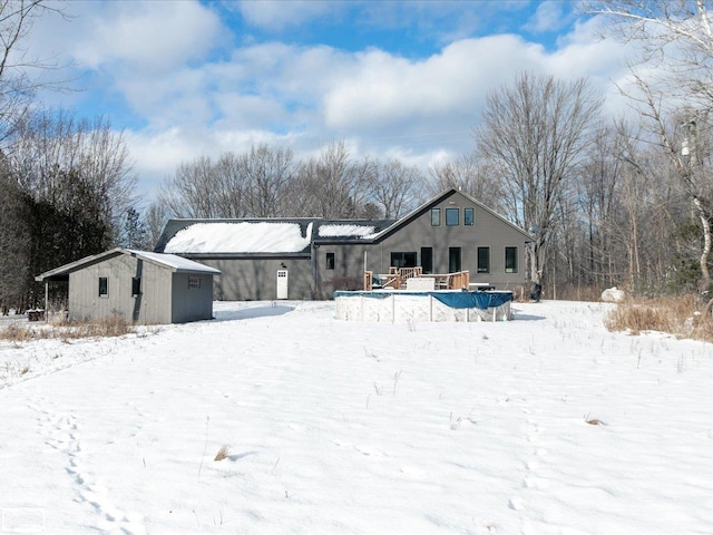 snow covered back of property with a shed