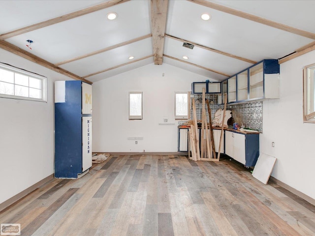 interior space featuring wood-type flooring, a wealth of natural light, and vaulted ceiling with beams