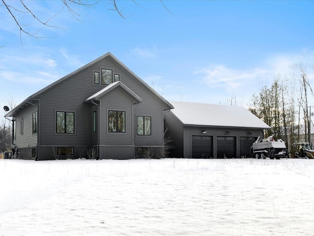 snow covered house with a garage