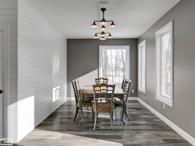 dining room with dark hardwood / wood-style flooring, a notable chandelier, and a healthy amount of sunlight