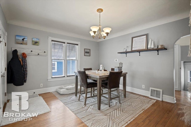 dining space with an inviting chandelier and hardwood / wood-style floors