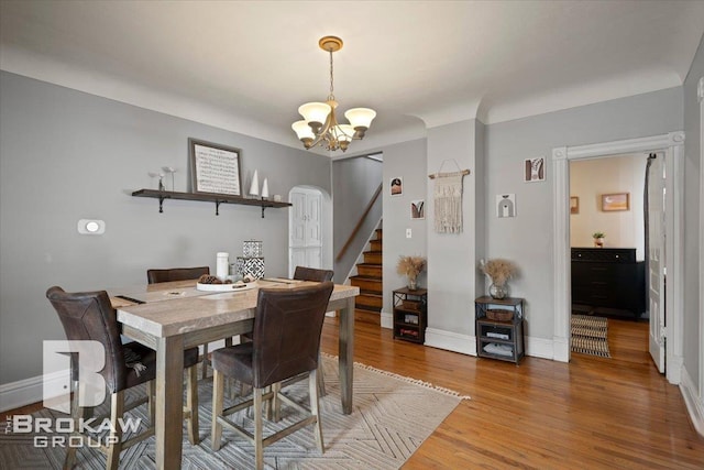 dining area featuring hardwood / wood-style flooring and an inviting chandelier