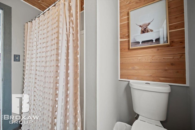 bathroom featuring a shower with curtain, wooden ceiling, wooden walls, and toilet