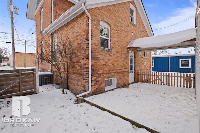 view of snow covered exterior with central AC