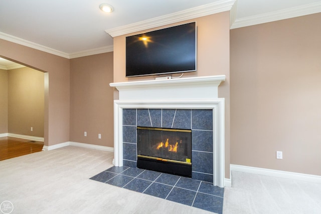 interior details with a tiled fireplace, carpet floors, and ornamental molding