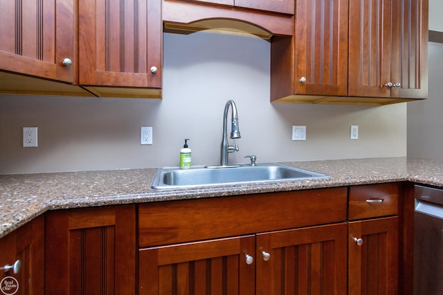 kitchen featuring sink, stainless steel dishwasher, and light stone countertops