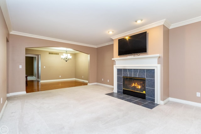 unfurnished living room with ornamental molding, a tile fireplace, and carpet floors