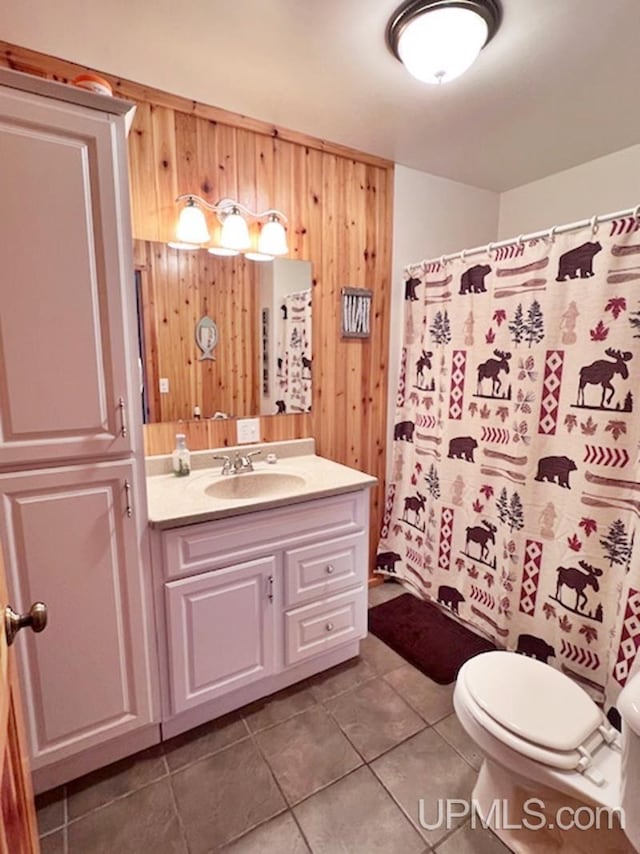 bathroom with a shower with shower curtain, toilet, tile patterned floors, wood walls, and vanity