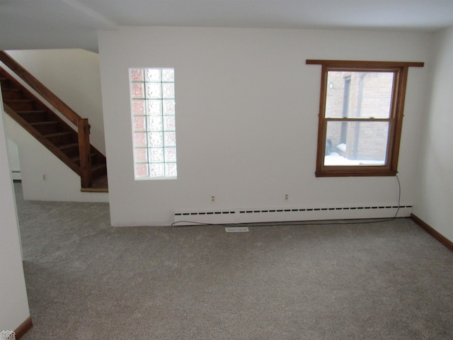 carpeted empty room with plenty of natural light and a baseboard heating unit