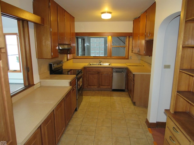 kitchen featuring stainless steel appliances, light tile patterned flooring, a baseboard radiator, and sink