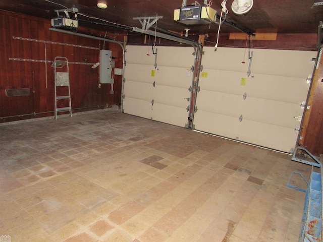 garage with a garage door opener, wood walls, and electric panel