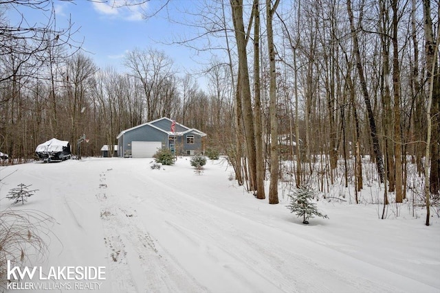 snowy yard featuring a garage