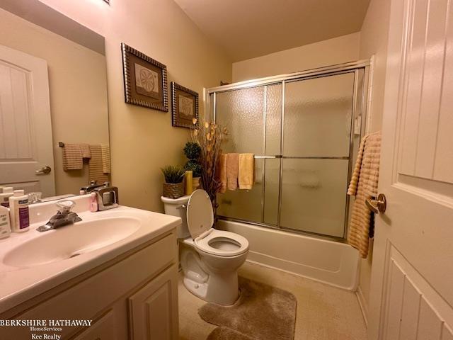 full bathroom featuring toilet, vanity, and shower / bath combination with glass door