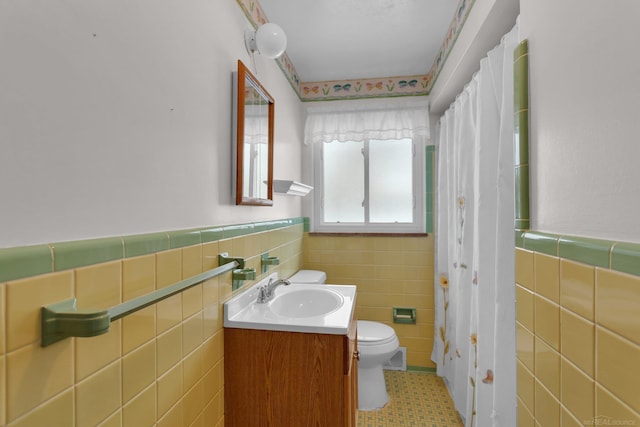 bathroom with tile walls, tile patterned floors, vanity, and toilet