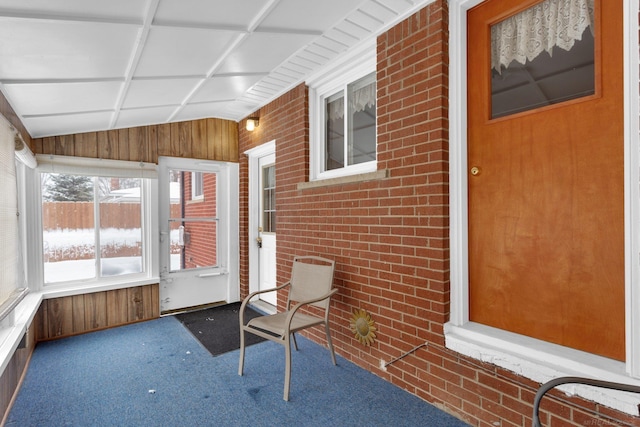 unfurnished sunroom featuring vaulted ceiling